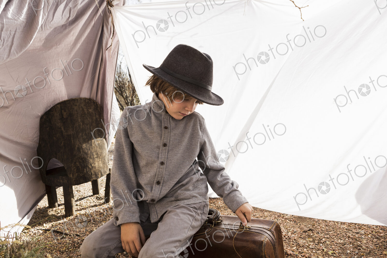 6 year old boy playing in an outdoor tent made of sheets