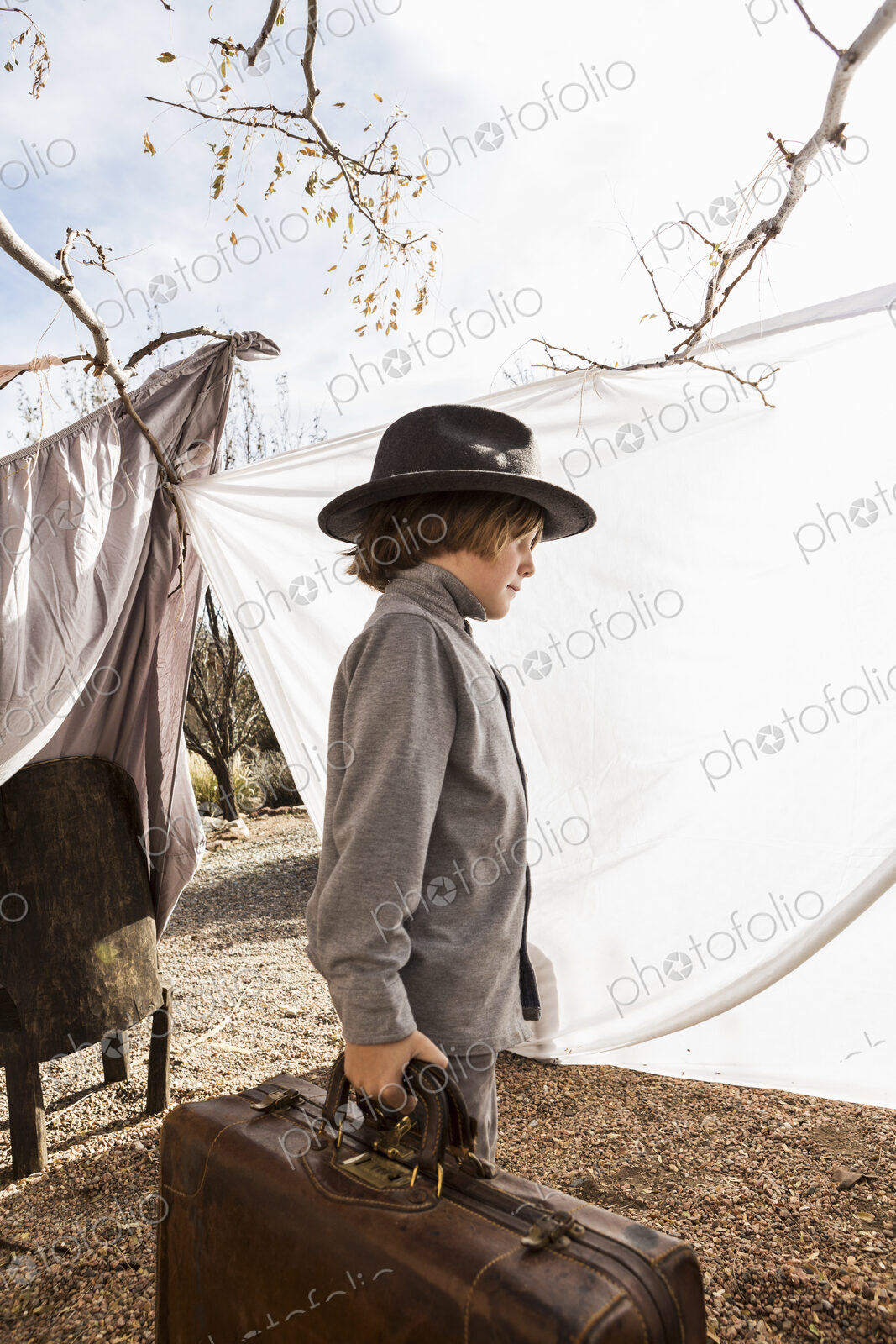 6 year old boy playing in an outdoor tent made of sheets