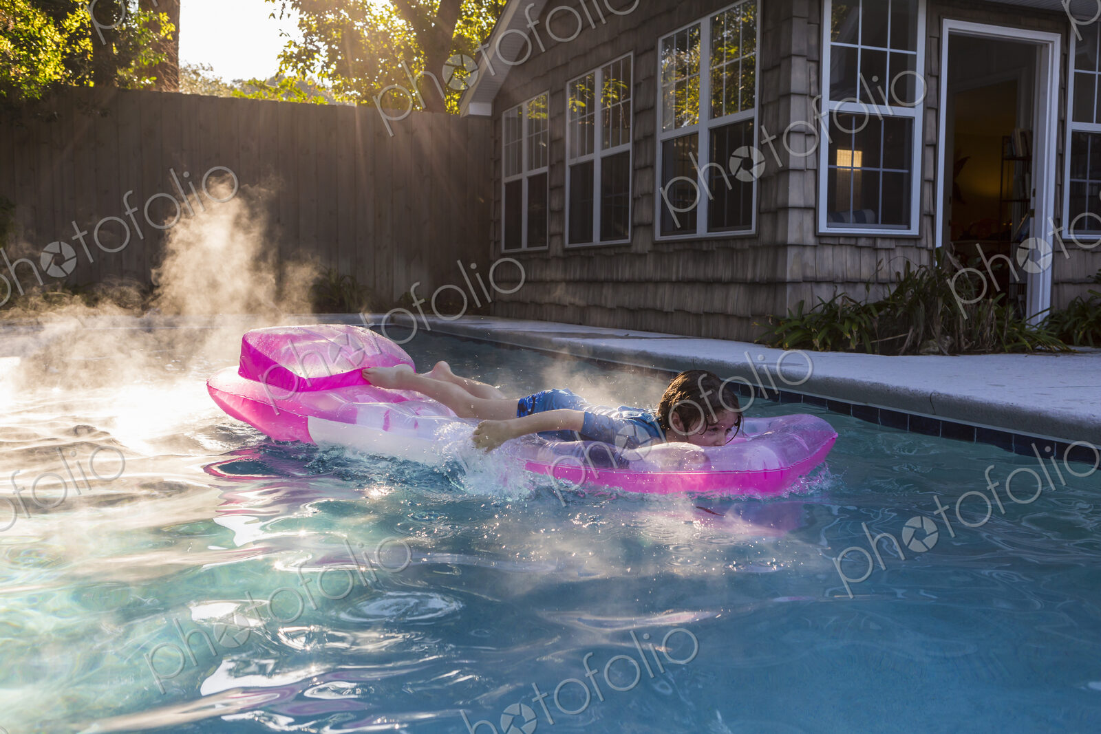 6 year old boy playing in pool at sunrise