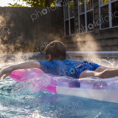 6 year old boy playing in pool at sunrise 6 year old boy playing in pool at sunrise