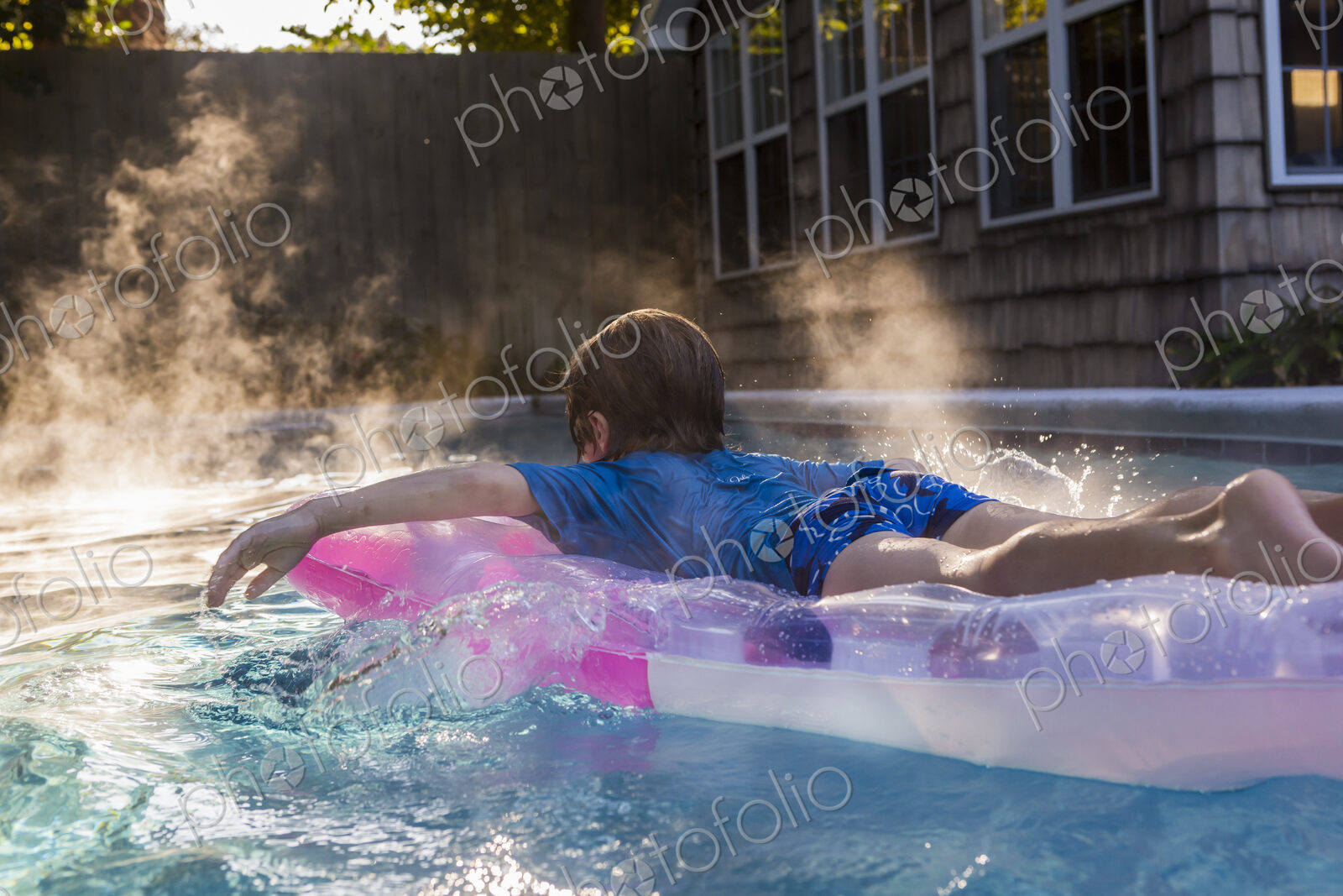 6 year old boy playing in pool at sunrise