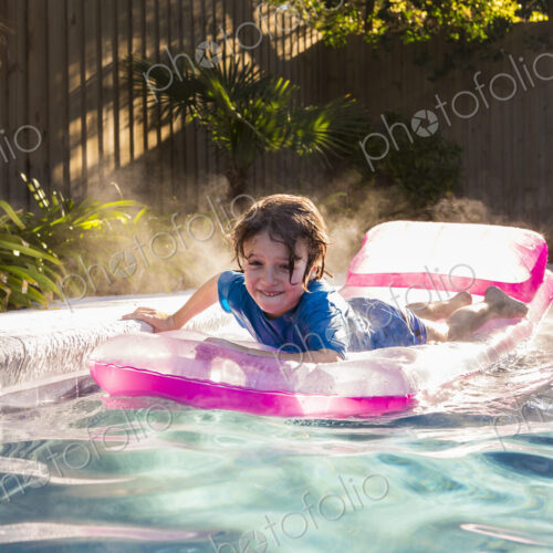 6 year old boy playing in pool at sunrise 6 year old boy playing in pool at sunrise