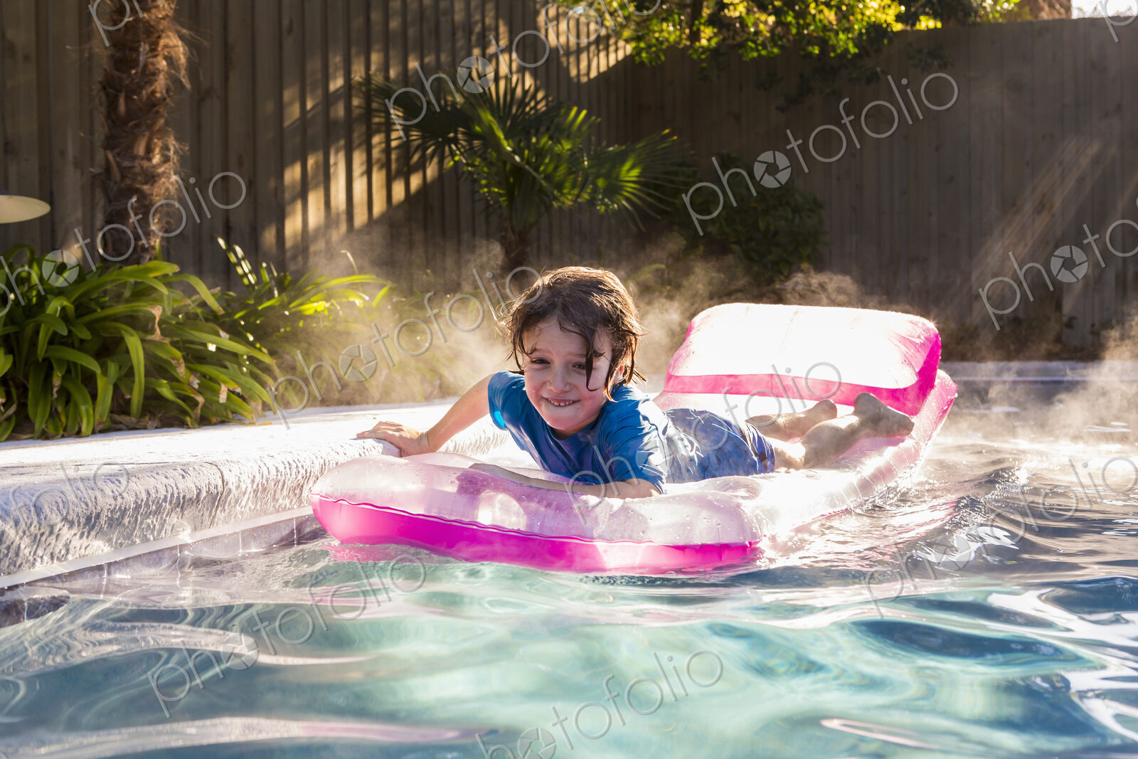 6 year old boy playing in pool at sunrise