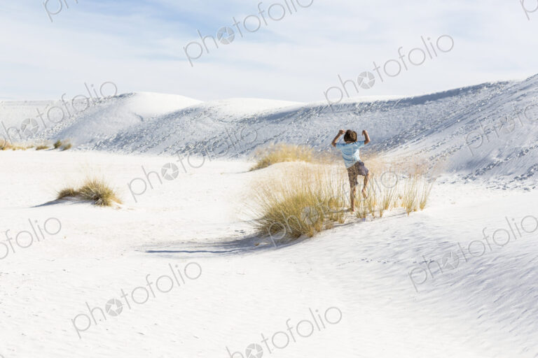 6 year old boy playing in sand dunes, White Sands Nat'l Monument, NM