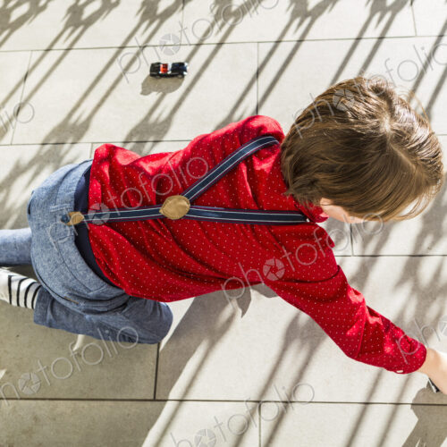 6 year old boy playing with toy cars on terrace 6 year old boy playing with toy cars on terrace
