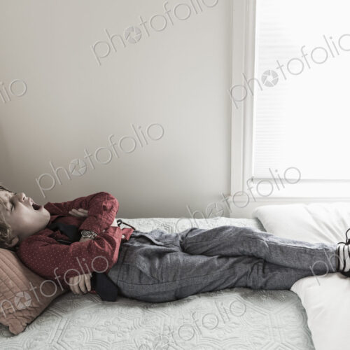 6 year old boy resting on his bed 6 year old boy resting on his bed
