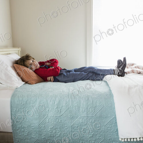 6 year old boy resting on his bed 6 year old boy resting on his bed