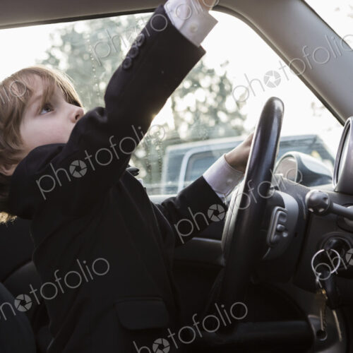6 year old boy sitting in car holding steering wheel 6 year old boy sitting in car holding steering wheel