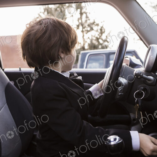 6 year old boy sitting in car holding steering wheel 6 year old boy sitting in car holding steering wheel