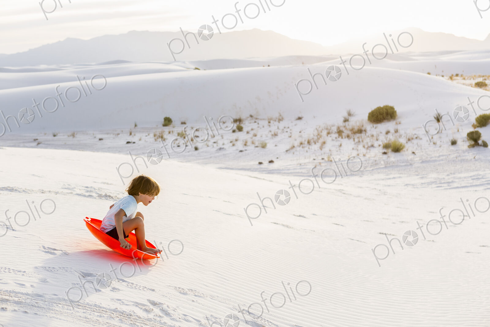 6 year old boy sledding down dunes, White Sands Nat’l Monument, NM