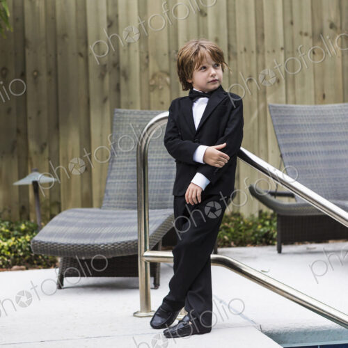 6 year old boy wearing formal attire standing by pool 6 year old boy wearing formal attire standing by pool