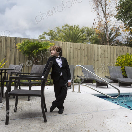 6 year old boy wearing formal attire standing by pool 6 year old boy wearing formal attire standing by pool