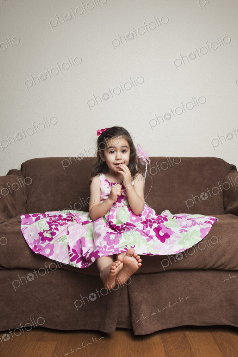 A 3 year old girl with long brown hair in a pink flowered cotton dress with the skirt…