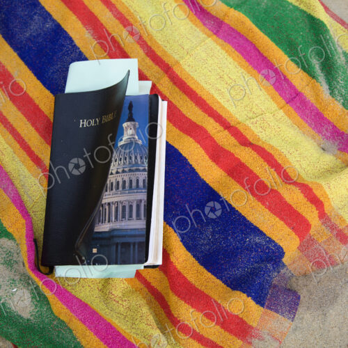 A Bible with a picture of the US Congress inside. It lays on a beach towel at the… A Bible with a picture of the US Congress inside. It lays on a beach towel at the…