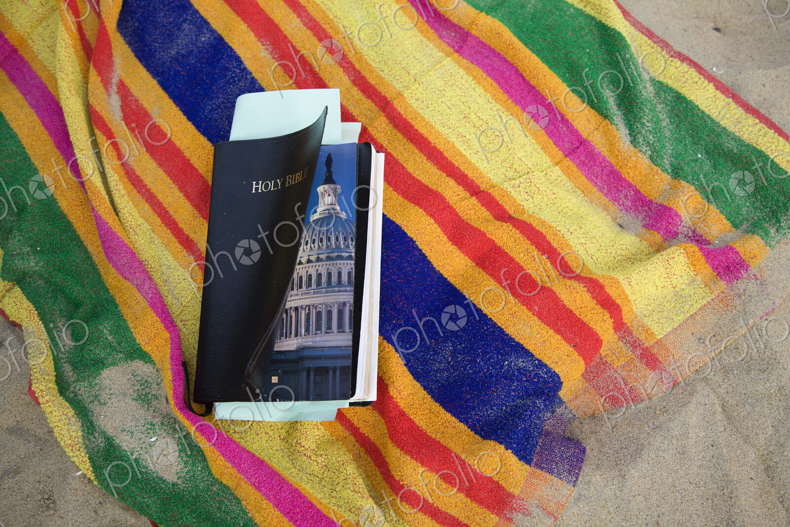 A Bible with a picture of the US Congress inside. It lays on a beach towel at the…