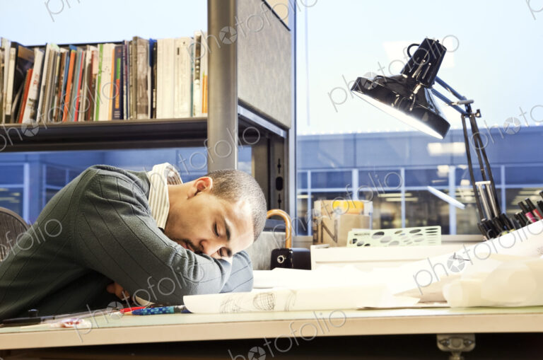 A Black man architect/designer taking a nap in his corporate office.