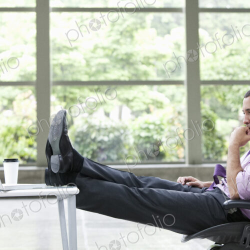 A Caucasian businessman pondering a problem at his desk with a laptop computer. A Caucasian businessman pondering a problem at his desk with a laptop computer.