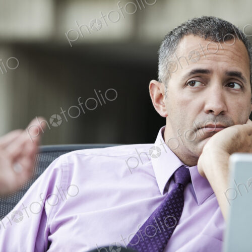 A Caucasian businessman pondering a problem while working on a laptop computer. A Caucasian businessman pondering a problem while working on a laptop computer.