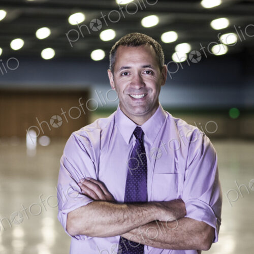 A Caucasian businessman standing in a dimly lit and dark exhibition area in a… A Caucasian businessman standing in a dimly lit and dark exhibition area in a…