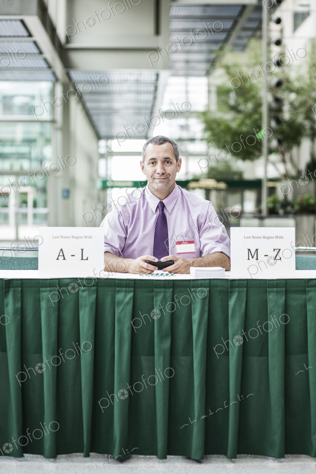 A Caucasian businessman working at registration desk in a convention center.