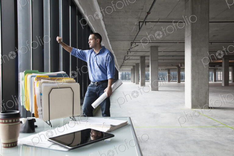 A Caucasian man at his temporary desk, in a new raw business space.