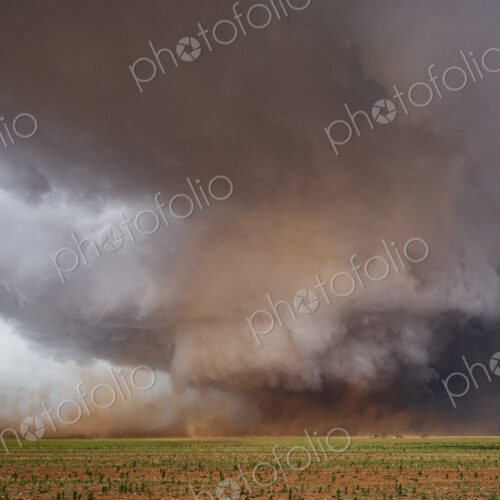 A Monster Wedge Tornado near Morton, clouds gathering in the sky above fields in a…