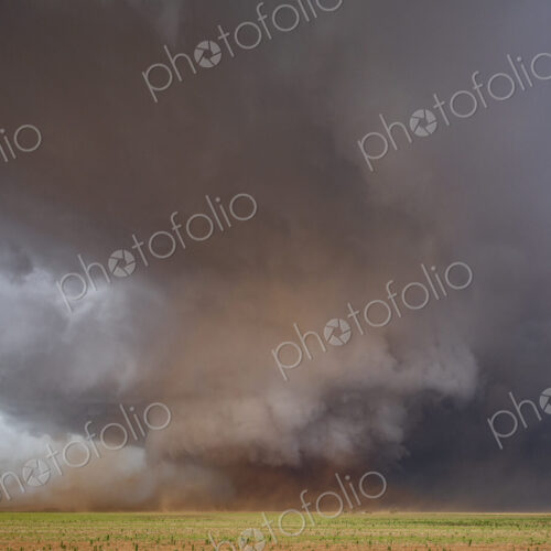 A Monster Wedge Tornado near Morton, clouds gathering in the sky above fields in a…