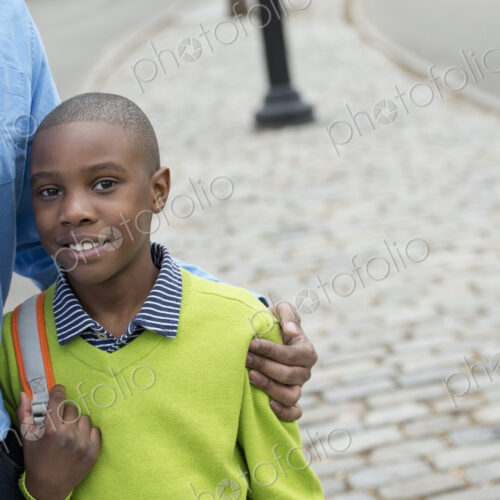 A New York city park in the spring. A boy holding a bag, beside his father.