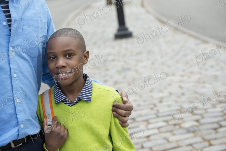 A New York city park in the spring. A boy holding a bag, beside his father.