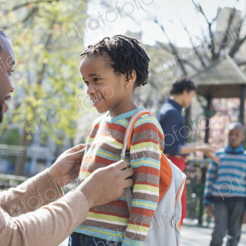 A New York city park in the spring. A family, parents and two boys spending time together.