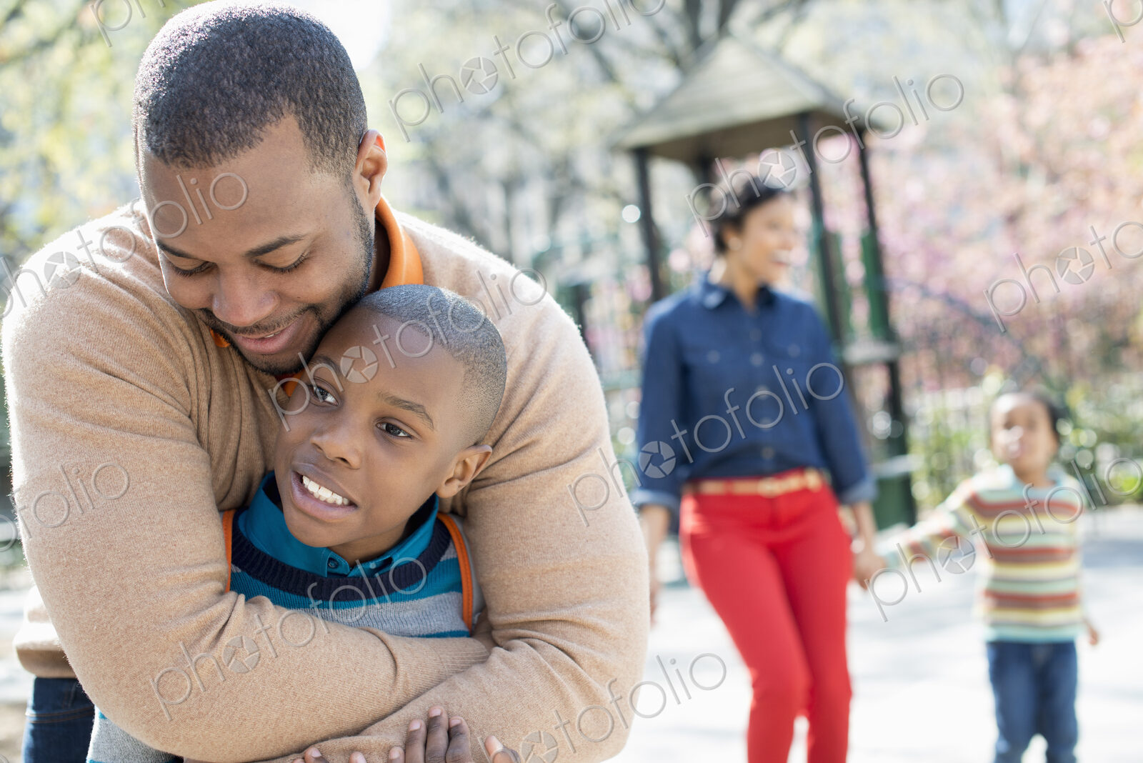 A New York city park in the spring. A family, parents and two boys spending time…