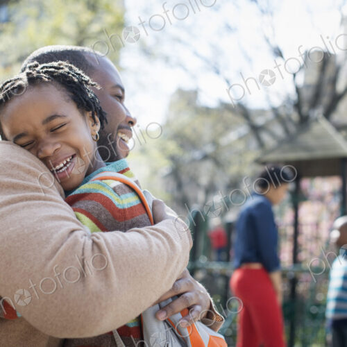 A New York city park in the spring. A family together. A father hugging his son.