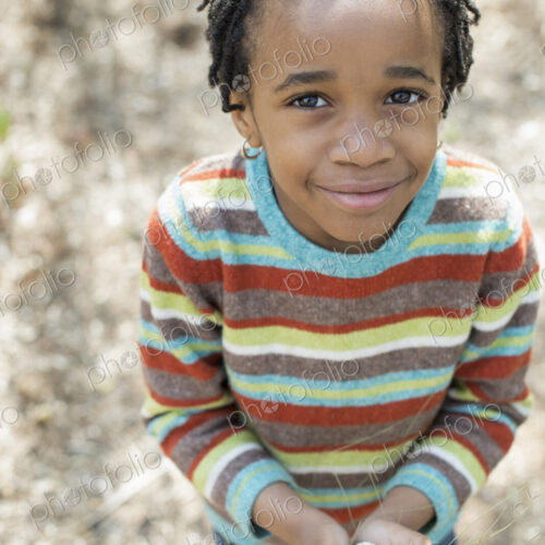 A New York city park in the spring. A small boy in a striped shirt, holding a nest…