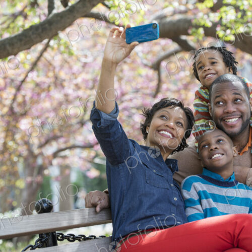 A New York city park in the spring. Cherry blossom. A woman taking a selfy picture…