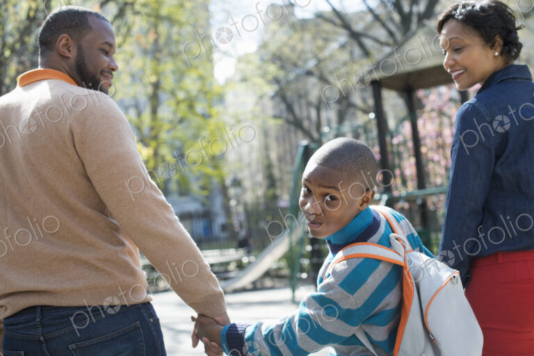 A New York city park in the spring. Sunshine and cherry blossom. A boy looking over…