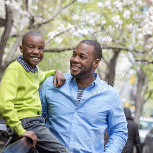 A New York city park in the spring. Sunshine and cherry blossom. A boy sitting on a… A New York city park in the spring. Sunshine and cherry blossom. A boy sitting on a…