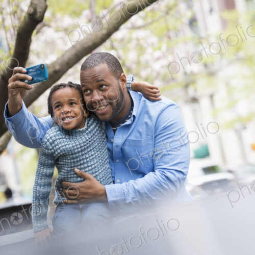 A New York city park in the spring. Sunshine and cherry blossom. A father and son side… A New York city park in the spring. Sunshine and cherry blossom. A father and son side…