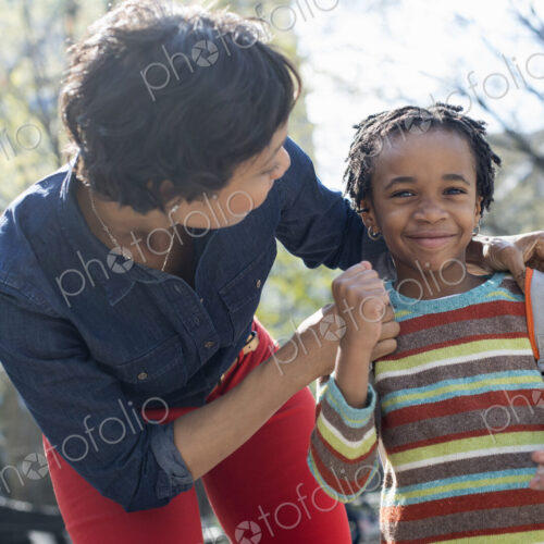 A New York city park in the spring. Sunshine and cherry blossom. A mother and son…