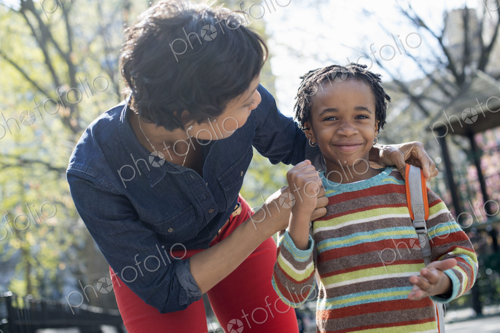 A New York city park in the spring. Sunshine and cherry blossom. A mother and son…