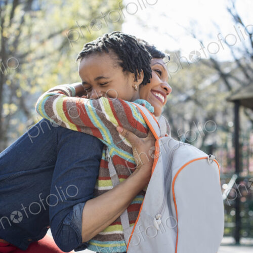 A New York city park in the spring. Sunshine and cherry blossom. A mother and son…