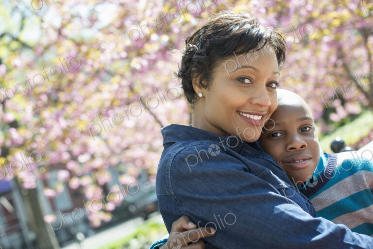 A New York city park in the spring. Sunshine and cherry blossom. A mother and son…
