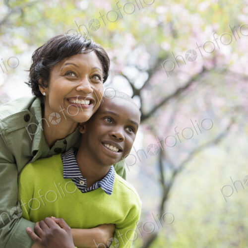 A New York city park in the spring. Sunshine and cherry blossom. A mother and son…