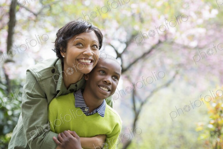A New York city park in the spring. Sunshine and cherry blossom. A mother and son…