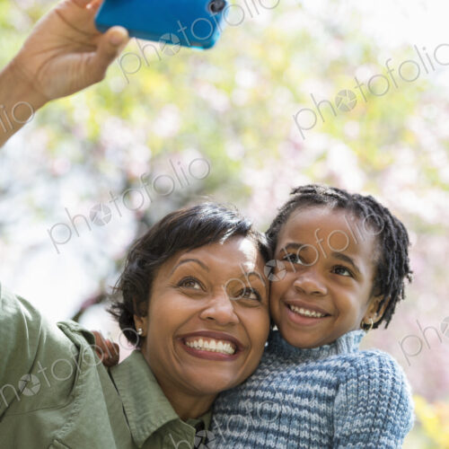 A New York city park in the spring. Sunshine and cherry blossom. A mother and son…