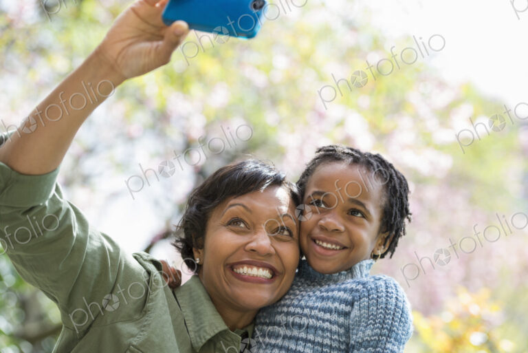 A New York city park in the spring. Sunshine and cherry blossom. A mother and son…