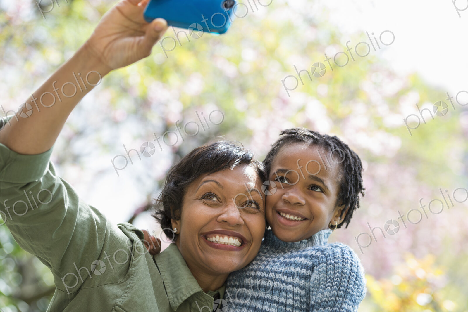 A New York city park in the spring. Sunshine and cherry blossom. A mother and son…