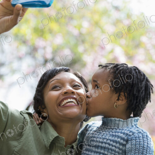 A New York city park in the spring. Sunshine and cherry blossom. A mother and son…