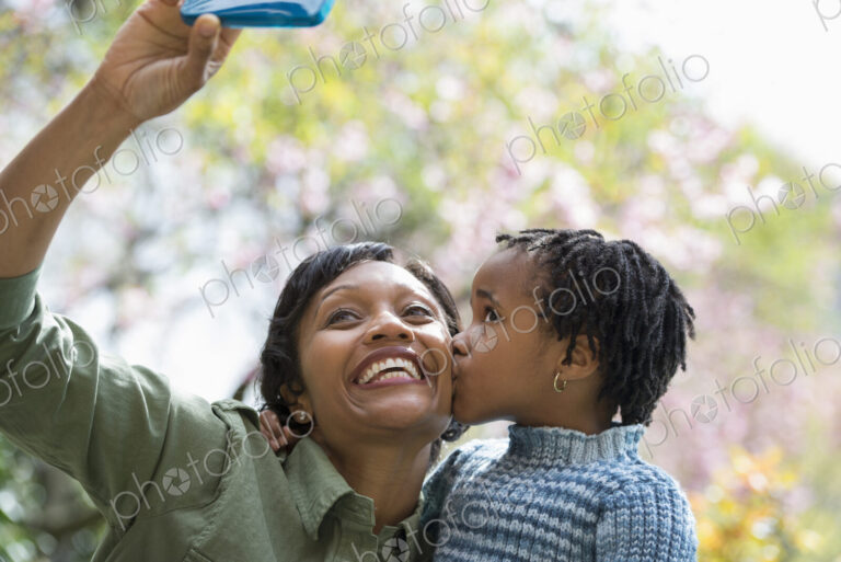 A New York city park in the spring. Sunshine and cherry blossom. A mother and son…