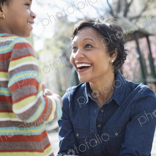 A New York city park in the spring. Sunshine and cherry blossom. A mother kneeling… A New York city park in the spring. Sunshine and cherry blossom. A mother kneeling…