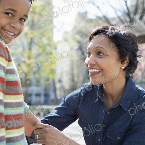 A New York city park in the spring. Sunshine and cherry blossom. A mother kneeling… A New York city park in the spring. Sunshine and cherry blossom. A mother kneeling…